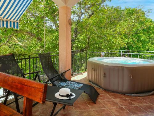 Un jacuzzi sentado en un patio con dos sillas. en Holiday Home Marija by Interhome, en Nedeščina