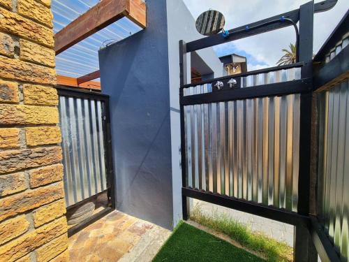 an open gate to a house with a fence at LieBling Place in Cape Town