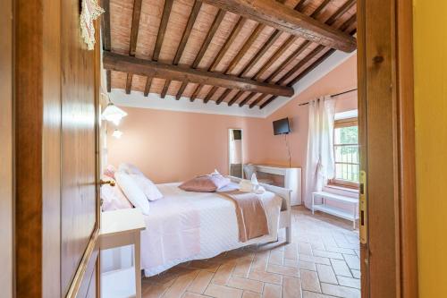 a bedroom with a white bed and a window at Masseria del bosco Poderuccio in Chianciano Terme