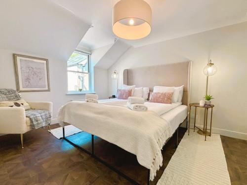 a bedroom with a large bed and a chair at Bright Mews House with Garage in Heart of Cambridge in Cambridge