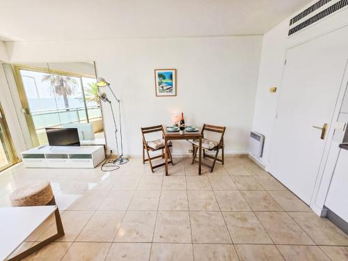 un salon avec une table et des chaises et une fenêtre dans l'établissement Apartment Le Panoramer by Interhome, à Cannes