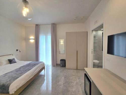 a bedroom with a bed and a flat screen tv at Just Light in San Leone