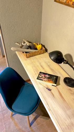 a wooden table with a blue chair next to a table at Le Bouquet Apart Hotel in San Carlos de Bariloche