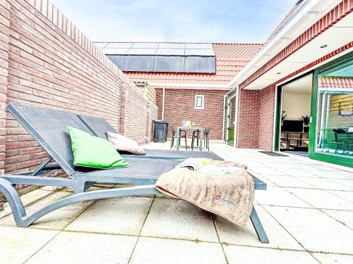 un patio con una mesa de picnic y una pared de ladrillo en Holiday Home Beach House Westkapelle 2B by Interhome, en Westkapelle