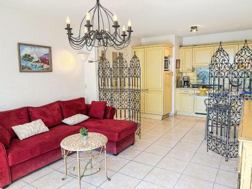 un salon avec un canapé rouge et une table dans l'établissement Apartment Le Grand Parc-11 by Interhome, à Saint-Aygulf