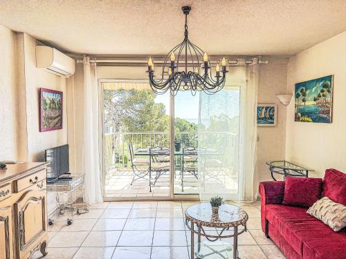 un salon avec un canapé rouge et une table dans l'établissement Apartment Le Grand Parc-11 by Interhome, à Saint-Aygulf