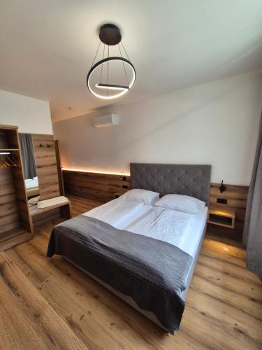 a bedroom with a large bed and a lamp at Berghamer's Gasthof Hotel in Neukirchen am Walde