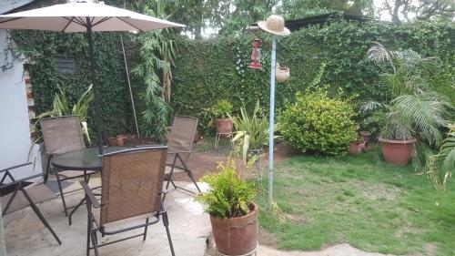 a patio with a table and chairs and an umbrella at Hostal El Jardin in León
