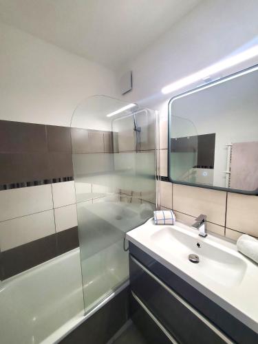 une salle de bain avec un lavabo et une douche avec un miroir dans l'établissement Vittoria Immobilier-375-Vue mer- REGLEMENT SUR PLACE -Chèques Vacances acceptés, à La Grande Motte