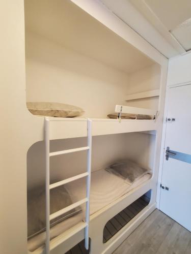 un petit placard avec des étagères blanches et une échelle dans l'établissement Vittoria Immobilier-375-Vue mer- REGLEMENT SUR PLACE -Chèques Vacances acceptés, à La Grande Motte