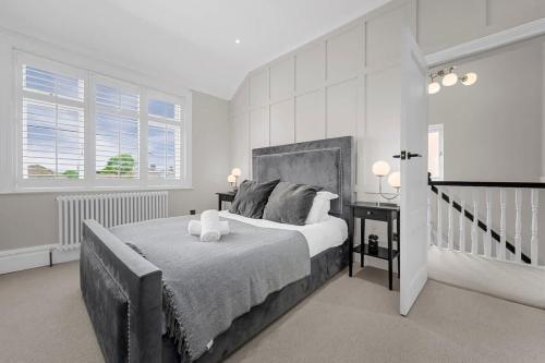 a white bedroom with a large bed and two windows at City SuperHost Hale Family Home in Hale