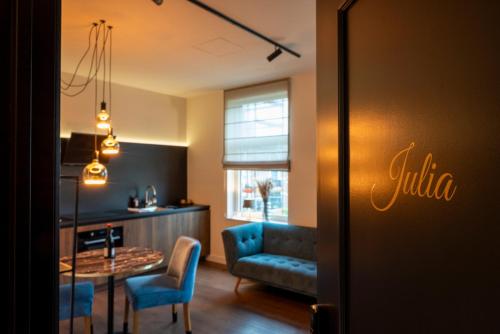 a living room with a blue couch and a table at Hof van In & Wellness in Hasselt