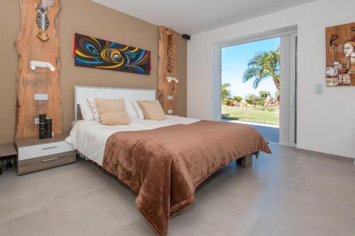 a bedroom with a bed with a painting on the wall at Casita Salpino in Sauzal
