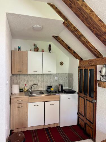 a kitchen with white cabinets and a sink at NINA Apartmani in Plav
