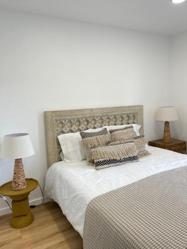 a bedroom with a large white bed with two lamps at Happy Stork Tróia Beach Flat in Troia