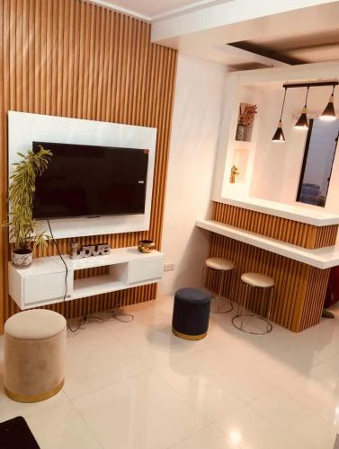 a living room with a large television and two stools at Z House of Guests 3 Airport Dvo in Davao City