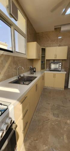 a kitchen with a sink and a microwave at White Mountain House in Sharīyah
