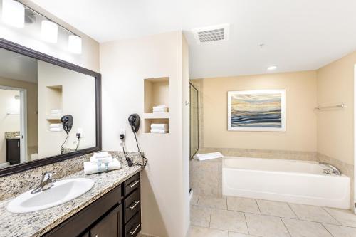 a bathroom with a tub and a sink and a bath tub at Vacation Village at Parkway in Orlando