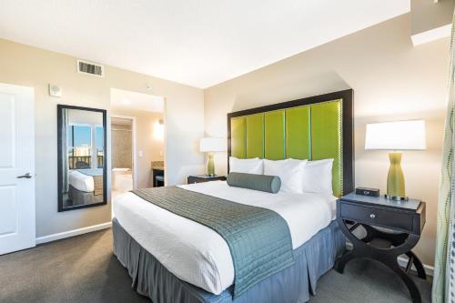 a bedroom with a large bed with a green headboard at Vacation Village at Parkway in Orlando