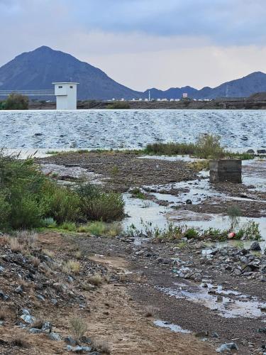 a body of water with mountains in the background at White Mountain House in Sharīyah