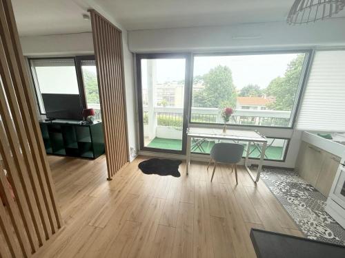 a living room with a table and a large window at Cocon lumineux proche hôpital Bagatelle in Talence