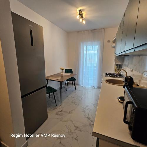 a kitchen with a table and a refrigerator in a kitchen at Studio Râșnov VMP Free Parking in Râşnov