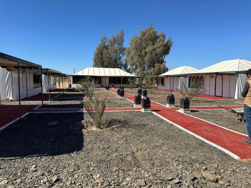 a person standing in front of a building with a red carpet at Amkrane luxury camps in Merzouga