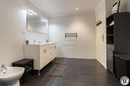 a white bathroom with a sink and a toilet at Le gîte du besson in Cassagne