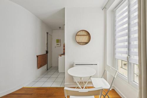 une salle à manger blanche avec une table et des chaises blanches dans l'établissement L’Insoupçonné, à Paris