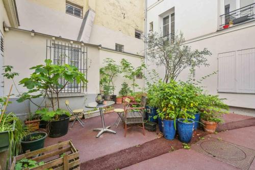 d'une terrasse avec une bande de plantes en pot et une table. dans l'établissement L’Insoupçonné, à Paris