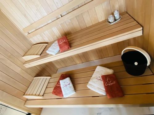 a small sauna with three towels sitting on shelves at Ô Cinquante - Gite Wellness, Marchin in Marchin