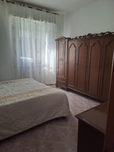 a bedroom with a large bed and wooden cabinets at la casa di rosa in San Benedetto del Tronto