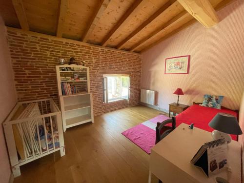 a small living room with a brick wall at Grand gîte du château in Montlaur