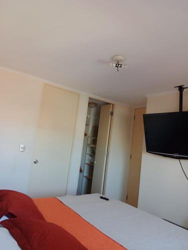 a bedroom with a bed and a flat screen tv at Hermosa vista bahía Valparaíso in Valparaíso