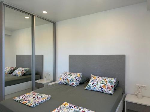 a room with a bed with pillows and a mirror at Palma Gena Makarska in Makarska