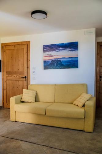a couch in a living room with a painting on the wall at Agriturismo Bonaventura in Montefiascone