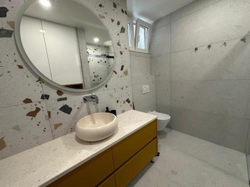 a bathroom with a sink and a mirror at Palma Gena Makarska in Makarska