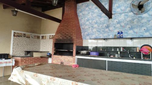 a kitchen with a brick oven and a brick wall at Chácara 2 irmãos in São Pedro