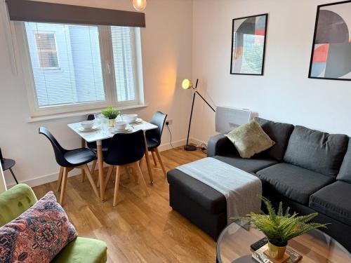 a living room with a couch and a table at Charming 1BR Apartment In Heart of Cardiff Bay in Cardiff