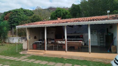 a house with a porch with a table and chairs at Chácara 2 irmãos in São Pedro