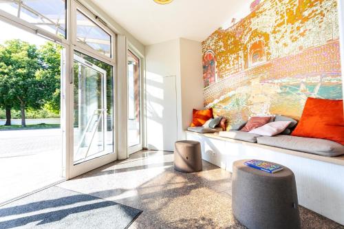 a living room with a couch and a wall at ACHAT Hotel Schwetzingen Heidelberg in Schwetzingen