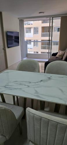 a table and chairs in a room with a window at Apartamento Plazuela Portal Del Prado in Barranquilla