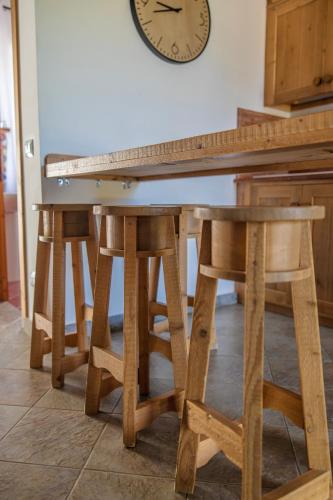 a table and stools with a clock on the wall at Agriturismo Bonaventura in Montefiascone