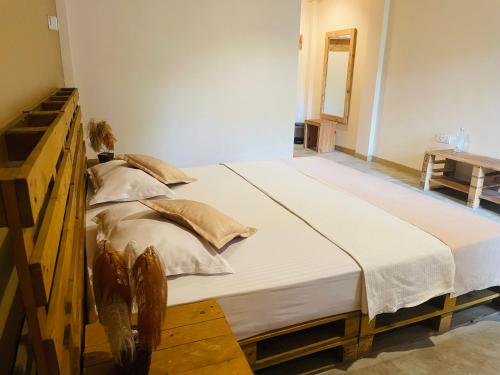 a large bed in a room with a wooden frame at Inside Out Nature Villa in Kandy