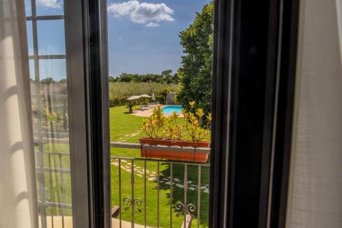 a window with a view of a pool and a yard at Agriturismo Bonaventura in Montefiascone