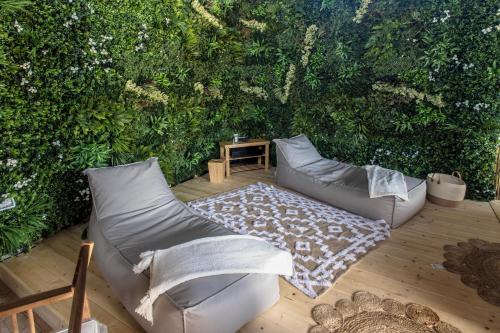 a patio with two couches and a table in front of a green hedge at Agriturismo Bonaventura in Montefiascone