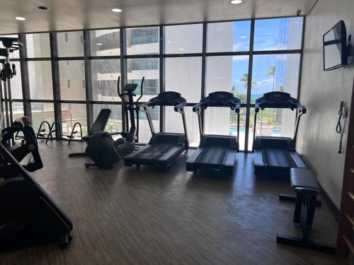 a gym with several treadmills in a room with windows at Beira Mar - Flat Beach Class Internacional - Boa Viagem 20º andar in Recife