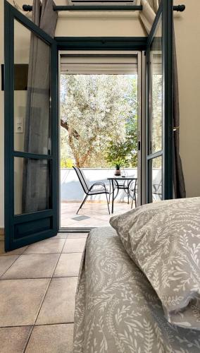 a bedroom with a door open to a patio at Melintas cozy apartments 2 in Plomari