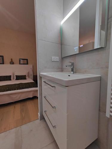 - une salle de bains blanche pourvue d'un lavabo et d'un lit dans l'établissement Large deluxe suite, historic center 2nd, à Bordeaux