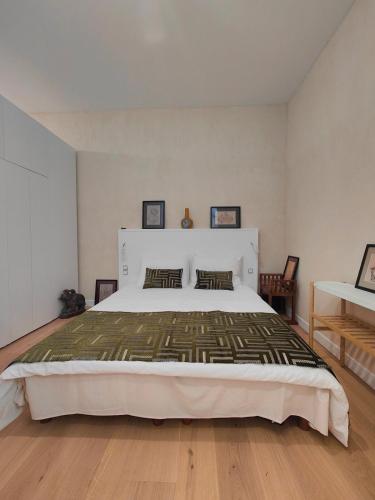 une chambre avec un grand lit blanc et du parquet dans l'établissement Large deluxe suite, historic center 2nd, à Bordeaux